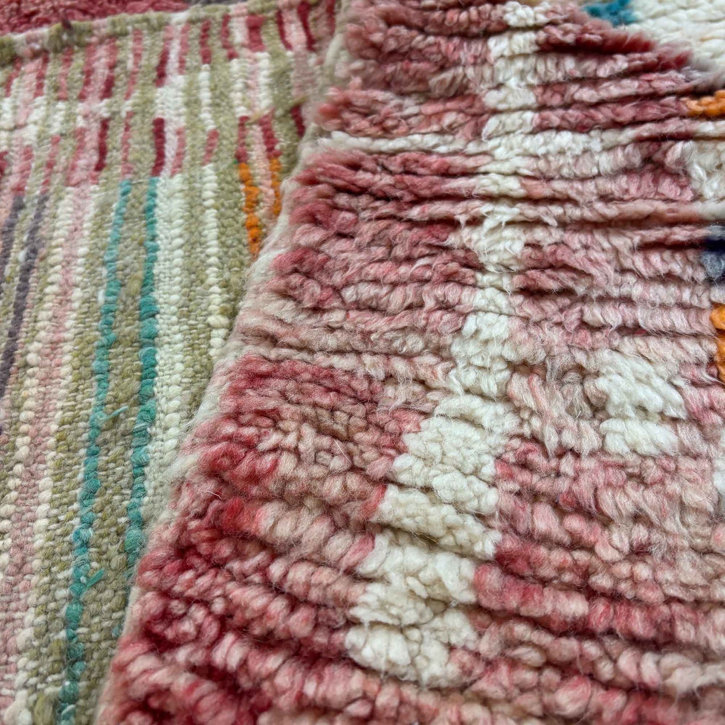 Détail de l’épaisseur et de la finition du tapis berbère Kadhena B25CLBO13 rose multicolore.
