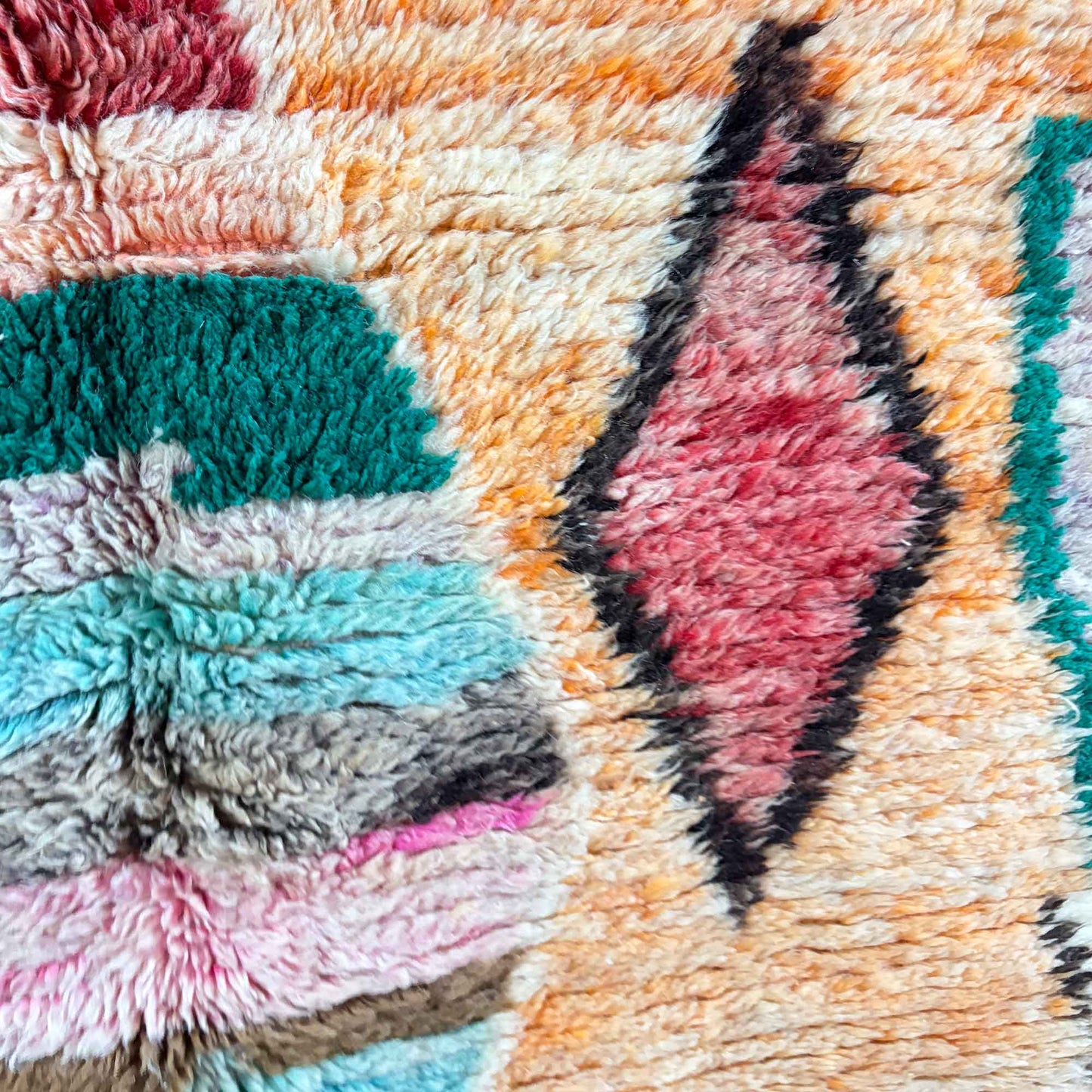 Gros plan sur la laine épaisse du tapis Boujaad Kadhena Nora aux tons pastel.