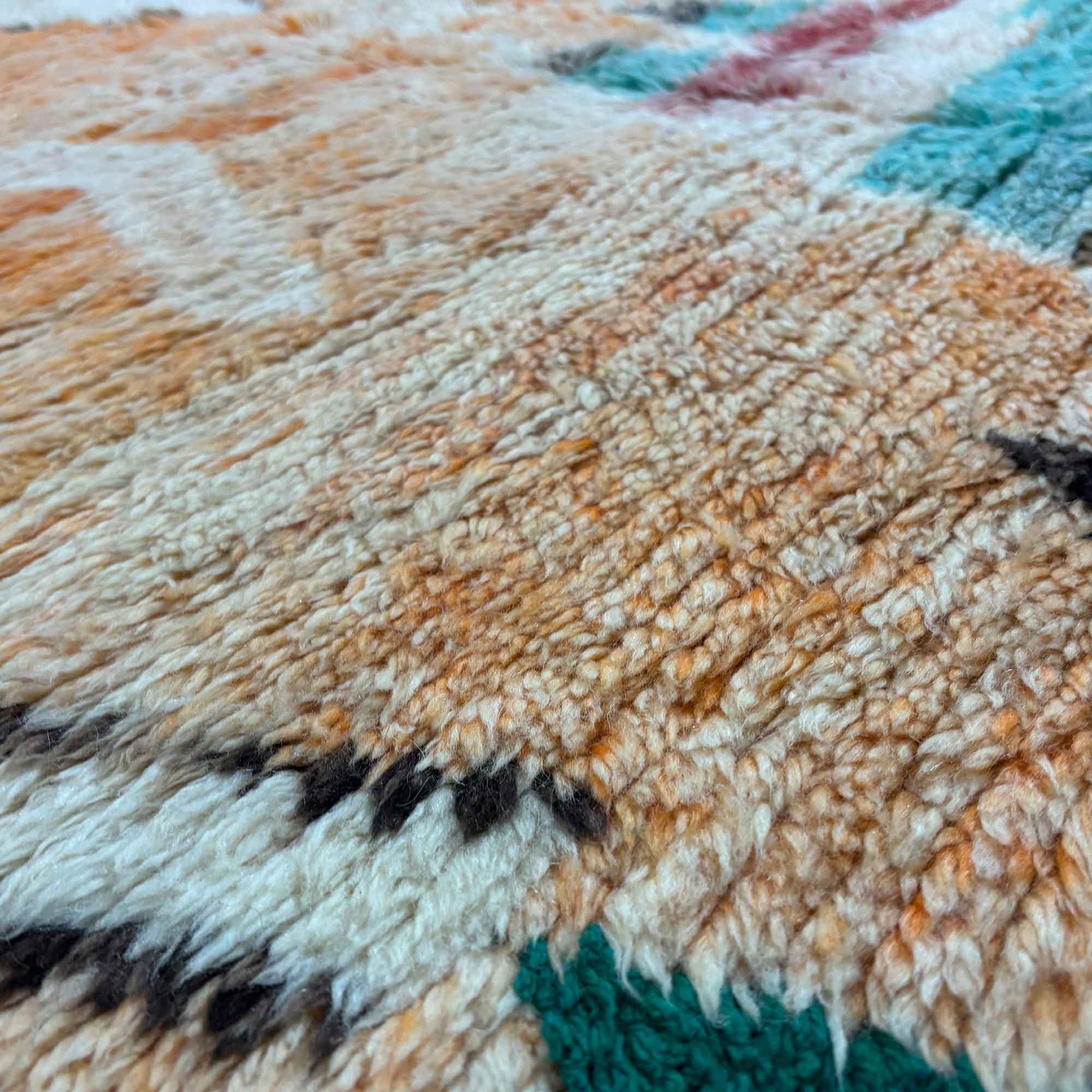 Macro sur les nuances roses et ivoire du tapis Boujaad Kadhena Nora.