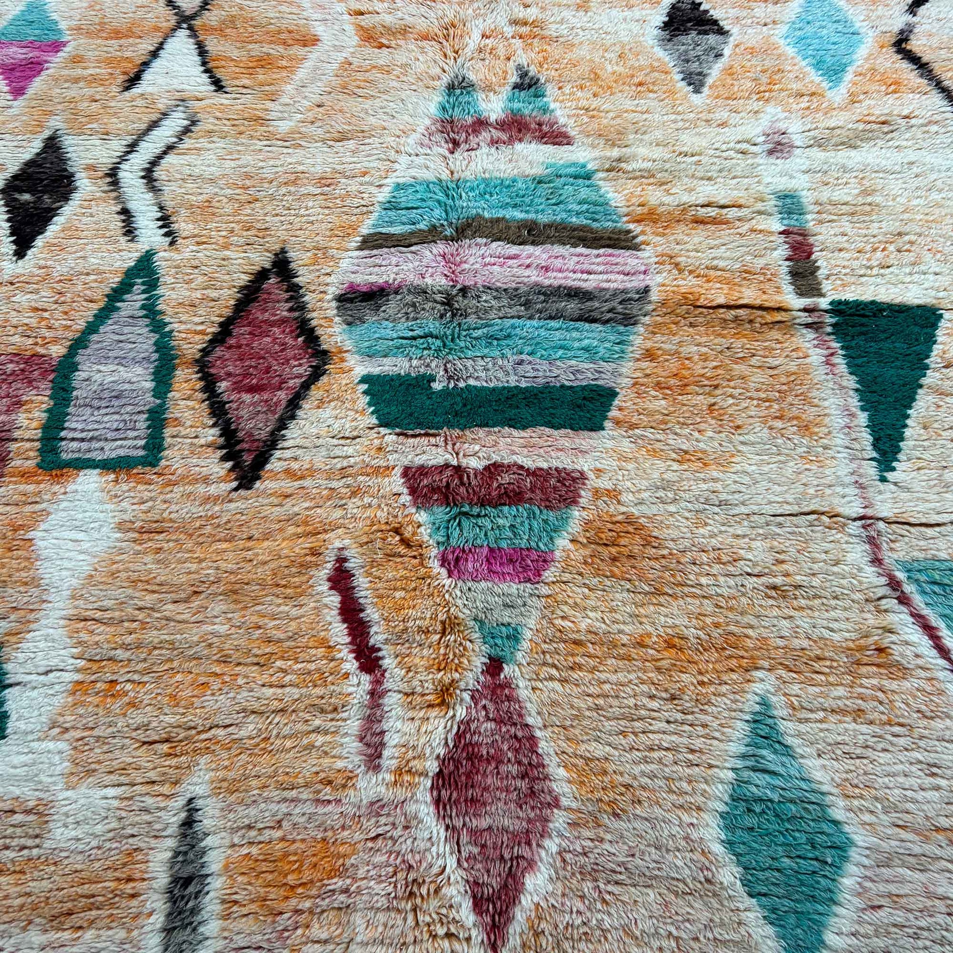 Vue de dessus du tapis Boujaad Kadhena Nora avec motifs géométriques multicolores.