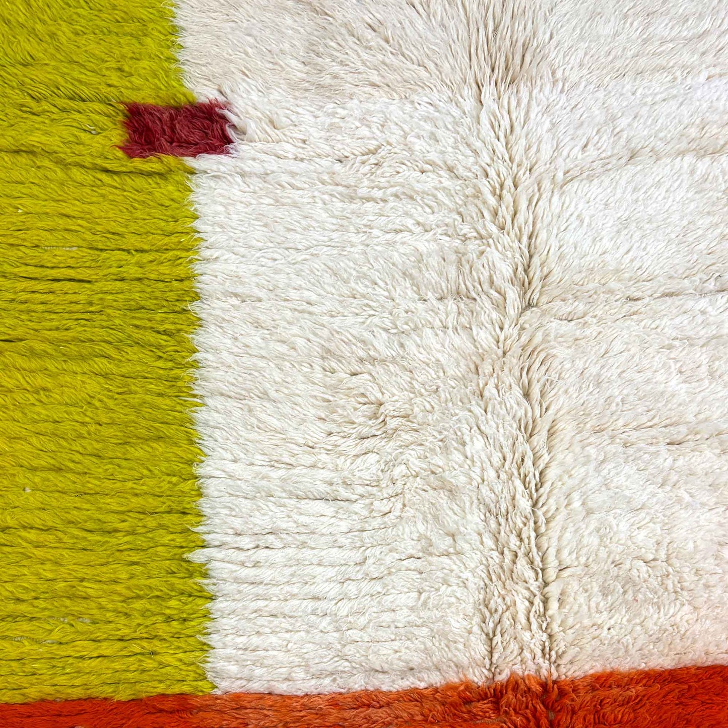 Gros plan sur la laine épaisse terracotta du tapis berbère Kadhena Paloma.