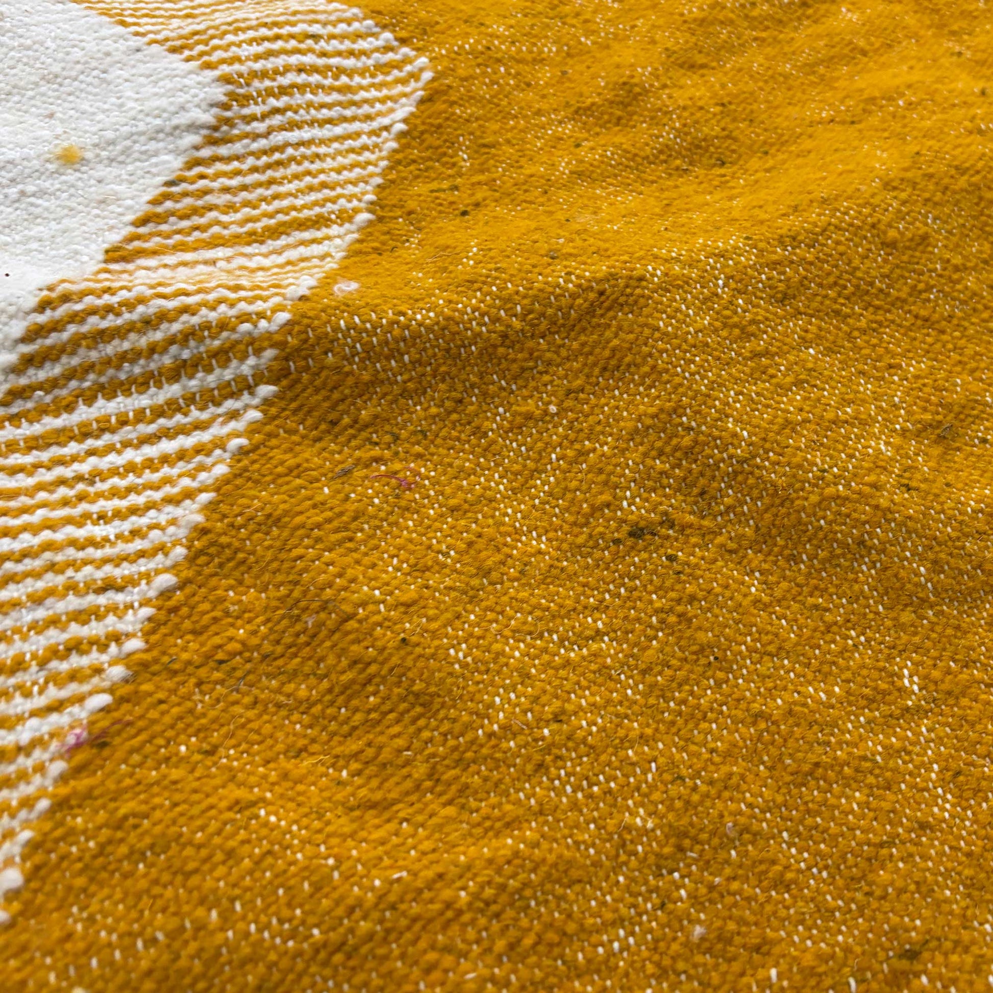 Gros plan sur le tissage du tapis Kilim Kadhena Solène en ivoire et moutarde.